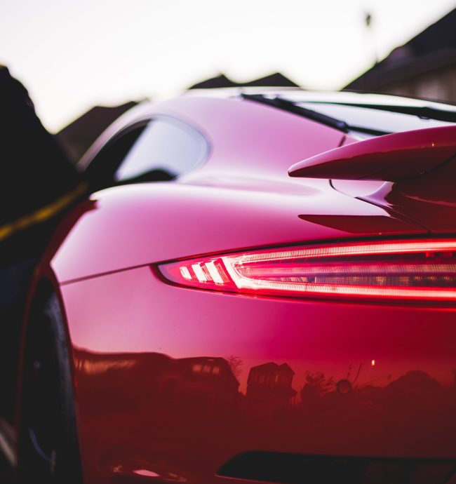 A back view of red Porsche in street